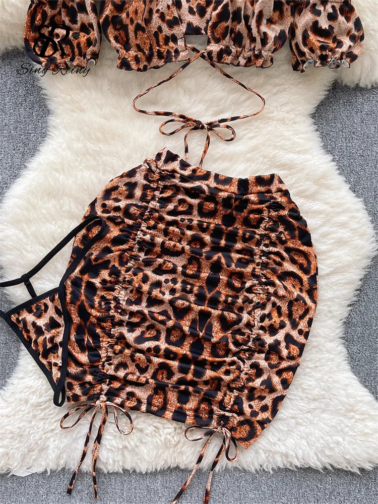 Conjuntos de tres piezas con estampado de leopardo para mujer, minitop con hombros descubiertos, faldas cortas con cordón y tangas, trajes de noche sexys Wanita